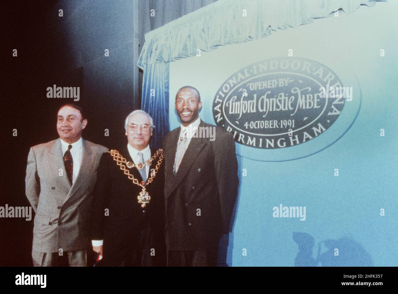 National Indoor Arena, King Edwards Road, Birmingham, 04/10/1991. Der Athlet Linford Christie, der Oberbürgermeister von Birmingham und ein dritter Mann posierten bei der offiziellen Eröffnung der National Indoor Arena in Birmingham neben einer Gedenktafel. I/N wird neben diesem Bild in Laings Negativregister aufgezeichnet, was bedeutet, dass es sich um ein Internegativ handelt. Es scheint im November 1991 vom Original kopiert worden zu sein. Der £50m Design and Construct-Auftrag für die National Indoor Arena (NIA) wurde im Januar 1989 von der Stadtverwaltung von Birmingham an die Laing Midlands Division vergeben. Es war offiziell in Betrieb Stockfoto