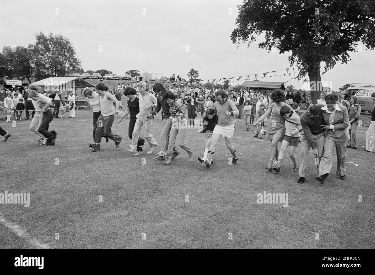 Laing Sports Ground, Rowley Lane, Elstree, Barnett, London, 09/06/1973. Teilnehmer, die während des jährlichen Gala-Tages auf dem Laing Sports Ground in Elstree an einem dreibeinigen Rennen teilnehmen. Der jährliche Gala-Tag fand am 9th. Juni 1973 auf dem Laing Sports Ground statt. Zu den Attraktionen gehörten Hundevorführungen der Polizei, Modellflugzeuge, die Royal British Legion Band, Kinderrennen und Sport. Am Abend gab es Tanz und Bingo im Club House, und 'Beer and Beat' im Festzelt. Über 2.000 Personen nahmen an der Gala Teil, und über 600 Personen blieben für die Abendunterhaltung. Stockfoto