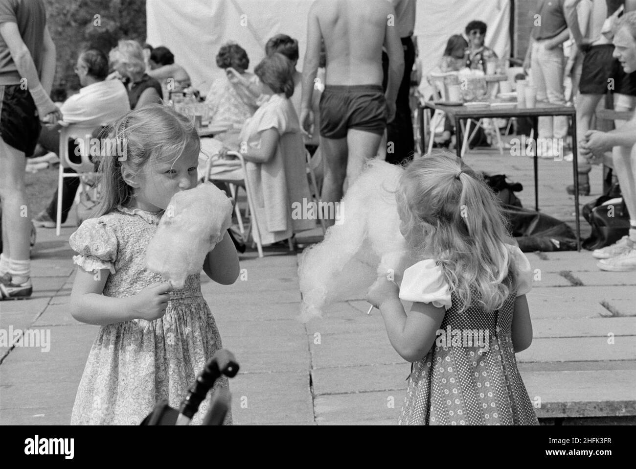 Laing Sports Ground, Rowley Lane, Elstree, Barnett, London, 25/06/1983. Zwei junge Mädchen, die während eines Laing-Sporttages Candyfloss essen. Dieser Sporttag wurde vermutlich im Laing Sports Club in Elstree abgehalten. Stockfoto