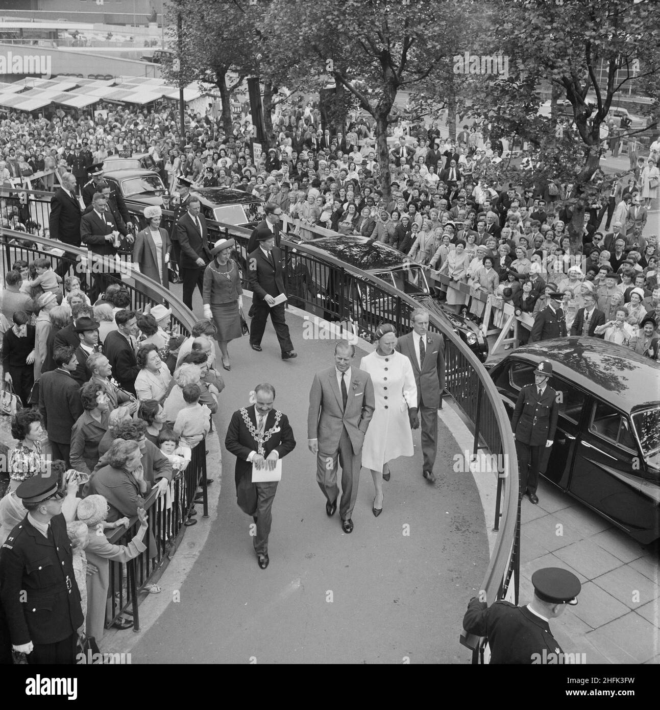 Bull Ring Centre, Birmingham, 29/05/1964. Die Eröffnungszeremonie für das Bull Ring Center, bei der S.H. Prinz Philip und die Gesellschaft die Wendelrampe hinunterlaufen, während eine riesige Menschenmenge zuschaut. Am 29th. Mai 1964 eröffnete seine Königliche Hoheit Prinz Philip, Herzog von Edinburgh, das Bull Ring Centre. Der Herzog besichtigte den Ort, besuchte unterwegs verschiedene Personen und enthüllte eine Gedenktafel im Center Court. Zu seinen Ehren fand dann in der Bankettsaal von Mekka ein formelles Mittagessen statt, das Teil der neuen Entwicklung des Bull Rings ist. Etwa 400 Gäste nahmen daran Teil, darunter der Oberbürgermeister von Birmingham, Alderman F. Stockfoto