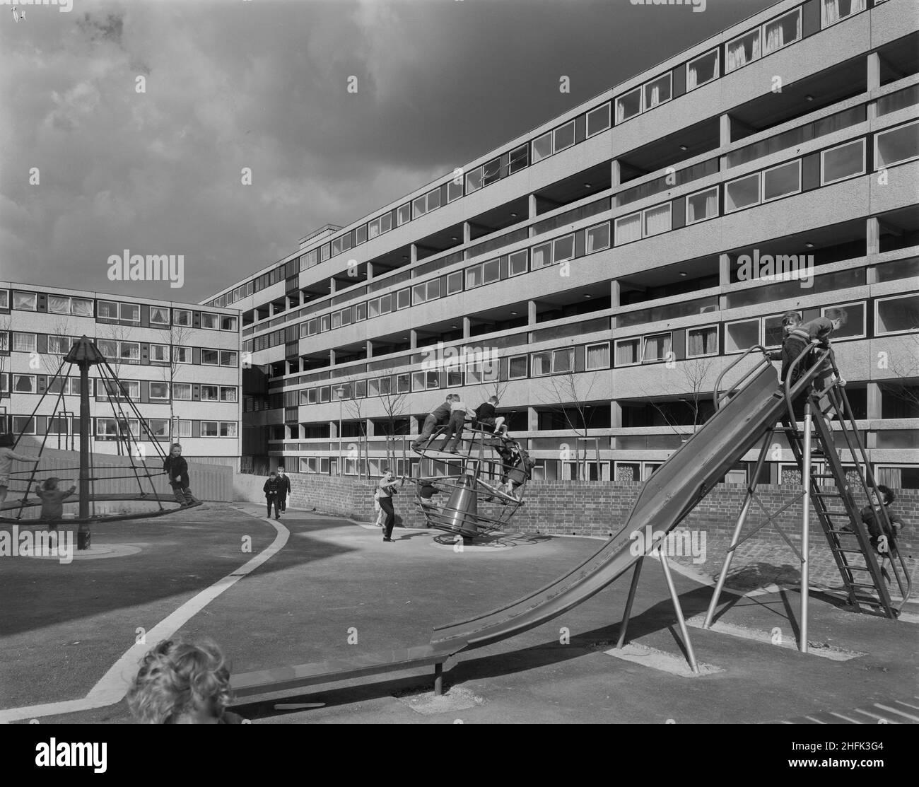 Lancashire Hill, Stockport, 28/04/1970. Kinder spielen auf einem der Spielplätze auf dem Lancashire Hill, umgeben von Wohnungen, die mit dem 12M Jespersen-System gebaut wurden. Die Region Manchester von Laing hatte Verträge über den Bau von 1200 Häusern für den County Borough of Stockport. In Lancashire Hill hatten sie zuvor zwei 22-stöckige Wohnblocks mit Storiform gebaut, die 198 Häuser, Und das auf diesem Foto gezeigte Wohnungskonzept, das aus sechs miteinander verbundenen Blöcken mit vier bis acht Stockwerken besteht, wurde mit dem Laing-System Jespersen aus dem Jahr 12M errichtet, das um drei Höfe gruppiert war, darunter zwei Kinderspielplätze und ein Stockfoto
