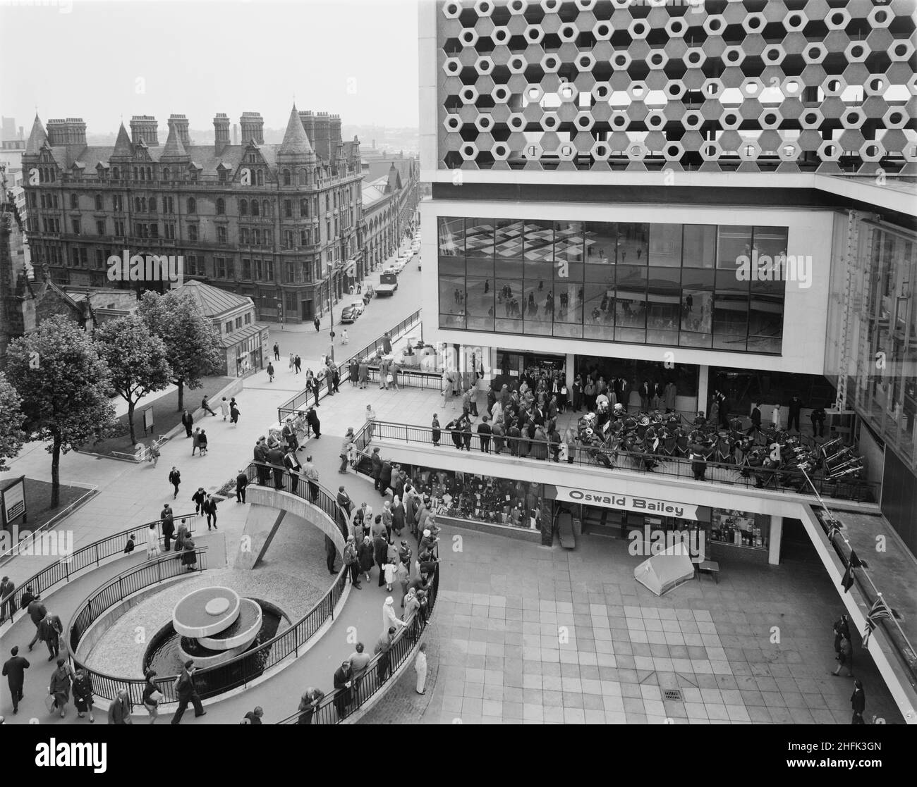 Bull Ring Centre, Birmingham, 27/06/1964. Eine RAF-Band, die am Osthof des Bull Ring Center auftrat, wobei die Käufer von der Wendelrampe im Vordergrund aus zusehen. Vom 14th. Bis 27th. Juni 1964 wurde im Bull Ring Center eine Ausstellung der Royal Air Force eingerichtet. Das Display beinhaltete einen britischen Kampfjet Folland Gnat. Während der zwei Wochen der Veranstaltung wurden auch Konzerte am East Court von einer RAF-Band abgehalten. Stockfoto