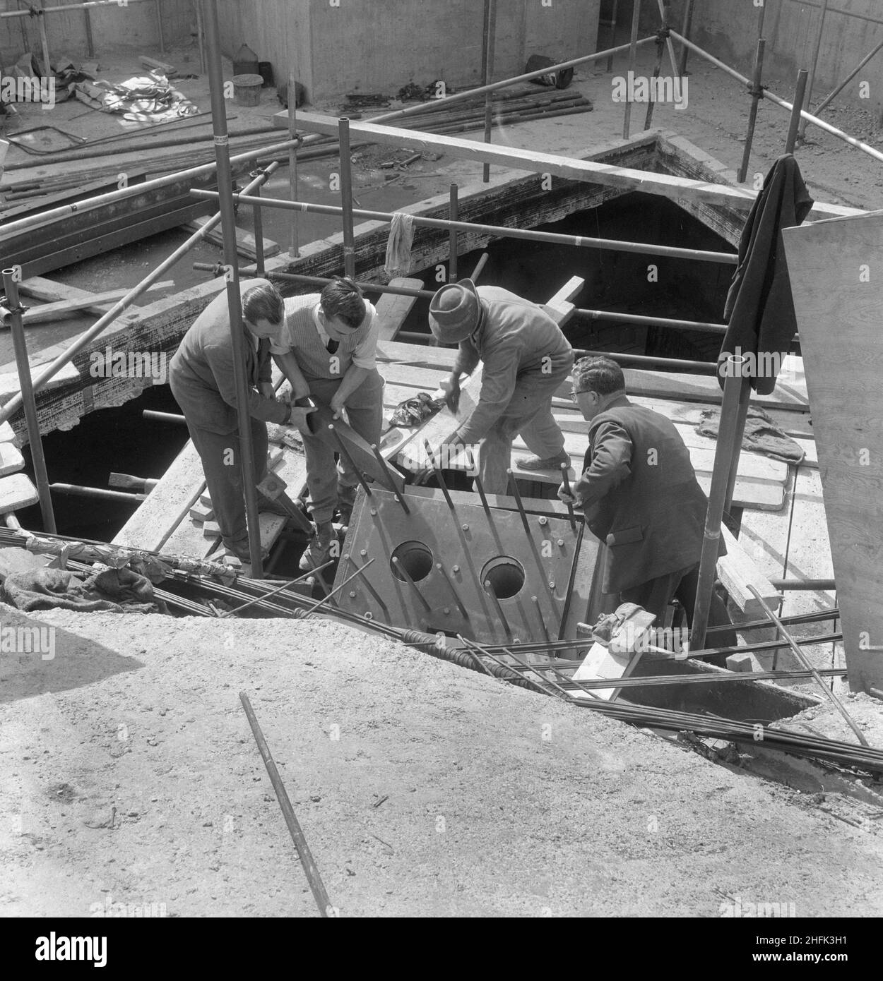 Commonwealth Institute, Kensington High Street, Kensington, London, 07/09/1961. Arbeiter, die während des Baus der Ausstellungshalle des Commonwealth Institute einen Keil in die Holzschalung oben auf einer Dachstützsäule einsetzten. Laing baute das Commonwealth Institute zwischen Oktober 1960 und Oktober 1962, um das ehemalige Imperial Institute zu ersetzen, das abgerissen werden sollte, um Platz für neue Einrichtungen am Imperial College zu schaffen. Das Gebäude bestand aus einem vierstöckigen Verwaltungsblock mit Bibliothek, Restaurant, Vorstandszimmer und Konferenzsaal sowie einem separaten zweistöckigen Block mit einem CI Stockfoto