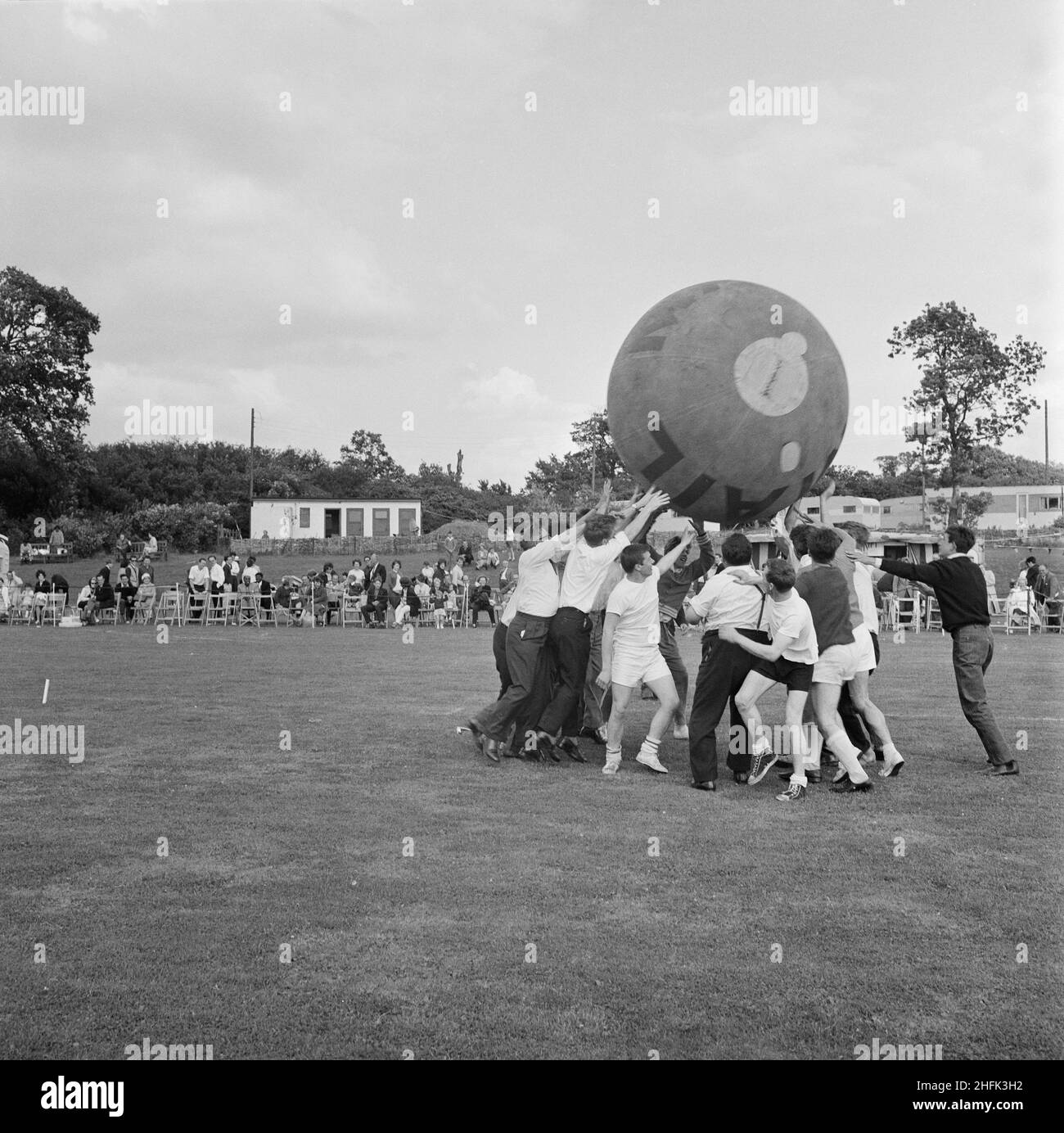 Laing Sports Ground, Rowley Lane, Elstree, Barnett, London, 22/06/1963. Ein Blick auf ein pushball-Spiel, bei dem der Ball über die Köpfe der Teilnehmer gehoben wurde, während des jährlichen Laing Sports Day auf dem Laing Sports Ground in Elstree. Im Jahr 1964 wurde Laings jährlicher Sporttag am 22nd. Juni auf dem Sportplatz auf der Rowley Lane in Elstree abgehalten. Zu den Veranstaltungen gehörten Kinderrennen, Tennis zwischen den Filialen, ein Fußballwettbewerb, ein Sportprogramm und Boule. Das Oxford-Team gewann den pushball-Wettbewerb. Stockfoto