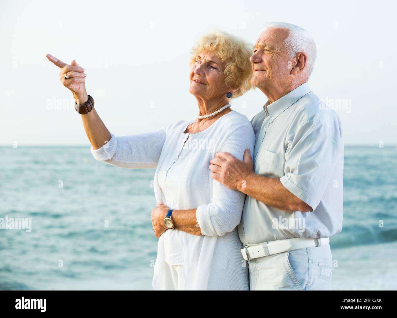Männchen und Weibchen zeigen mit dem Finger auf den Ozean Stockfoto