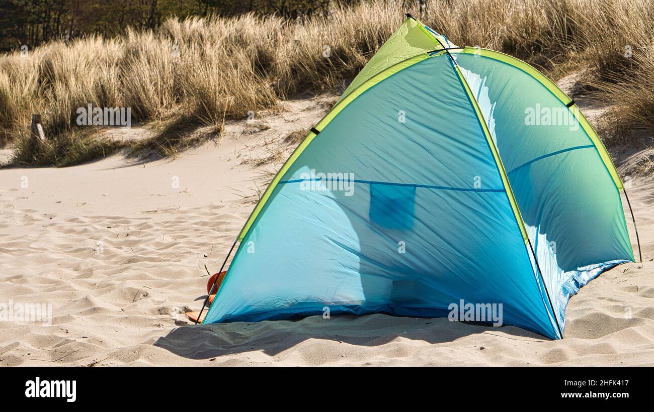 Ein Zelt zum Windschutz am Ostseestrand im Sommerurlaub. Vor den Dünen im Sand vor dem Meer. Erholsame Ferien in s Stockfoto