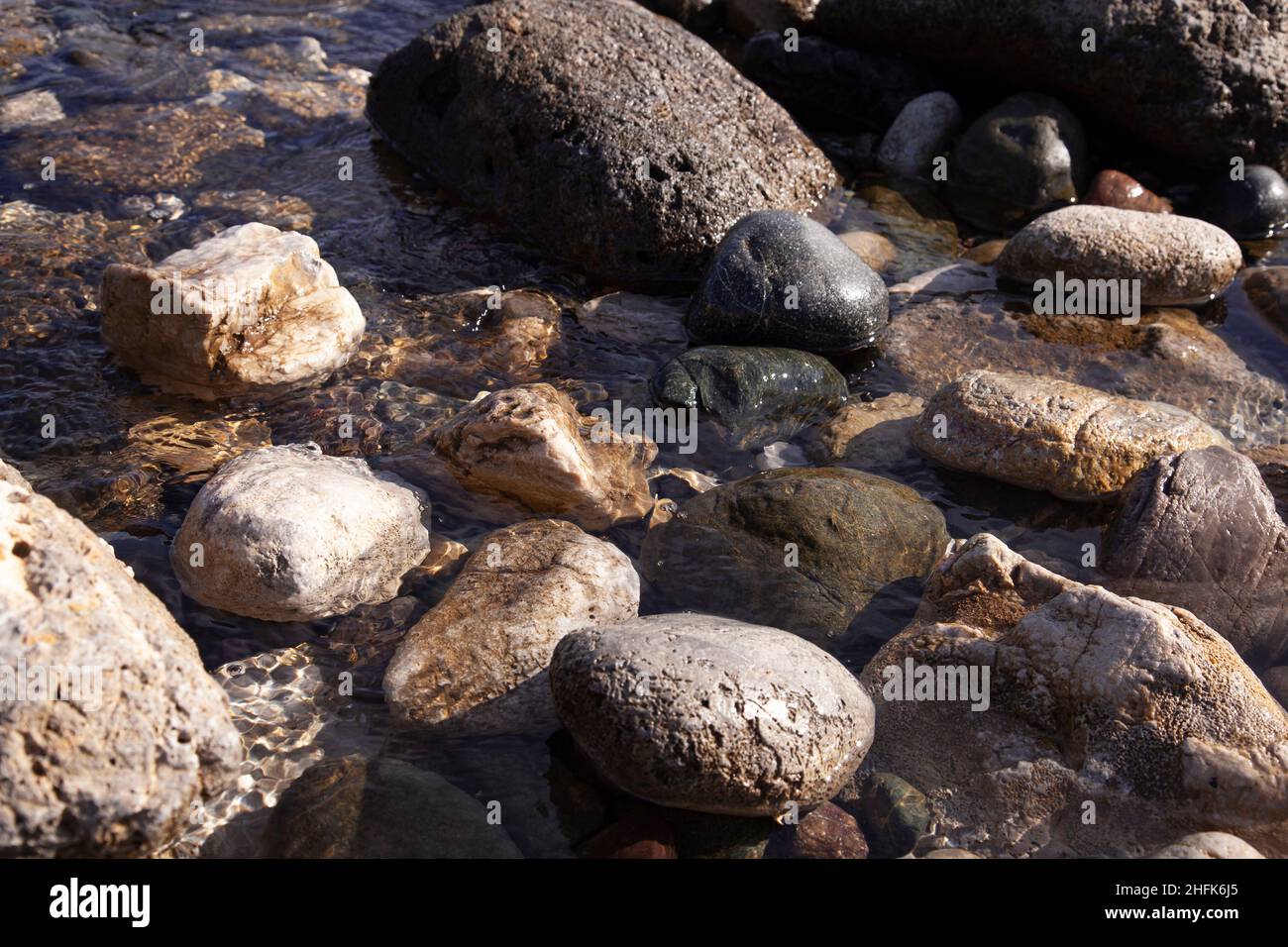 Natursteine in verschiedenen Größen im Meer. Nahaufnahme. Stockfoto