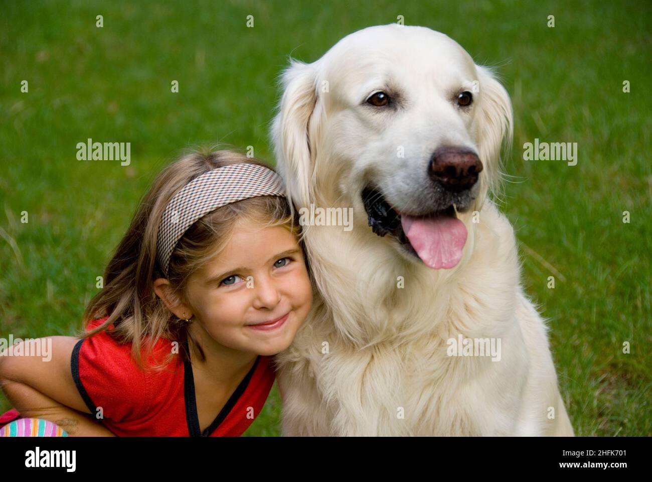 Kleines achtjähriges Mädchen mit ihrem Golden Retriever Hund Stockfoto