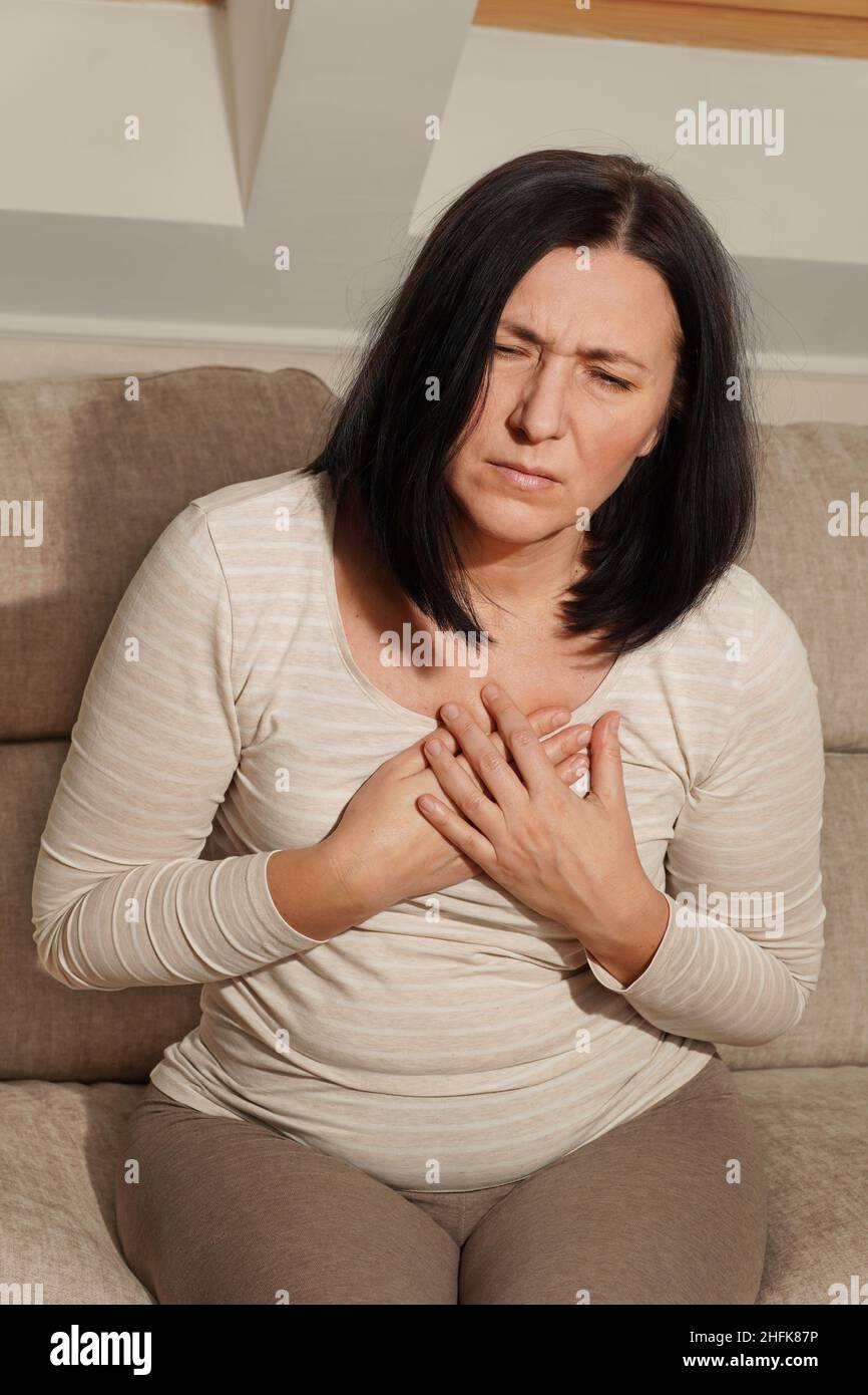 Ältere Frau mittleren Alters mit einem Herzinfarkt. Frau mit Brustschmerzen. Gesundheitsfürsorge und kardiologisches Konzept. Stockfoto