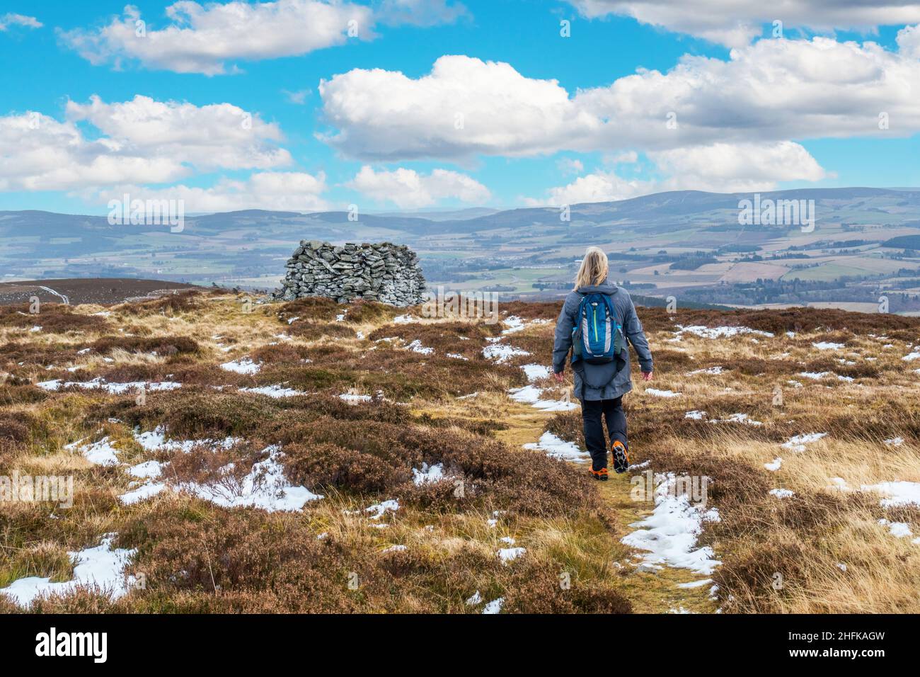Ein Wanderer nähert sich Lord Arthurs Cairn auf Lord Arthur's Hill in den Correen Hills in der Nähe von Alford, Aberdeenshire, Schottland Stockfoto