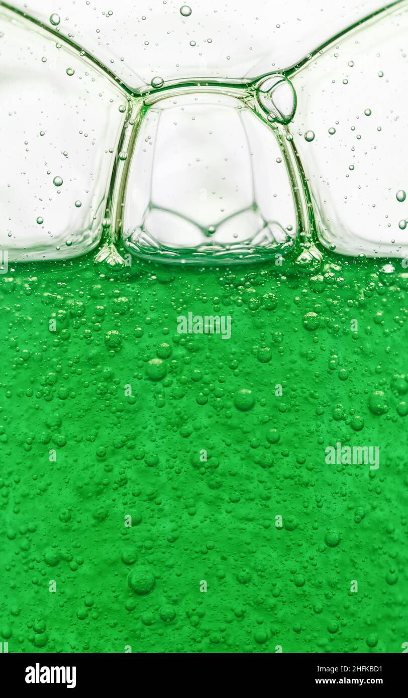 Blasen in durchscheinendem grünem Shampoo. Abstrakter Hintergrund, Nahaufnahme Stockfoto