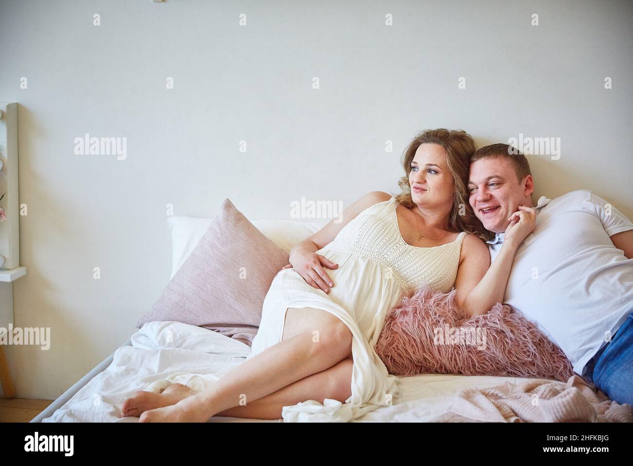 Junge Familie auf dem Bett im Schlafzimmer. Stockfoto