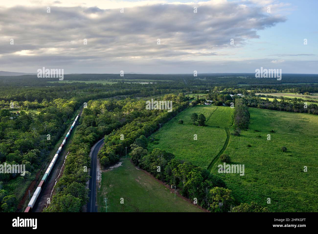 Luftaufnahme eines allgemeinen Güterzuges, der das Dorf Yandaran Queensland Australia passiert Stockfoto