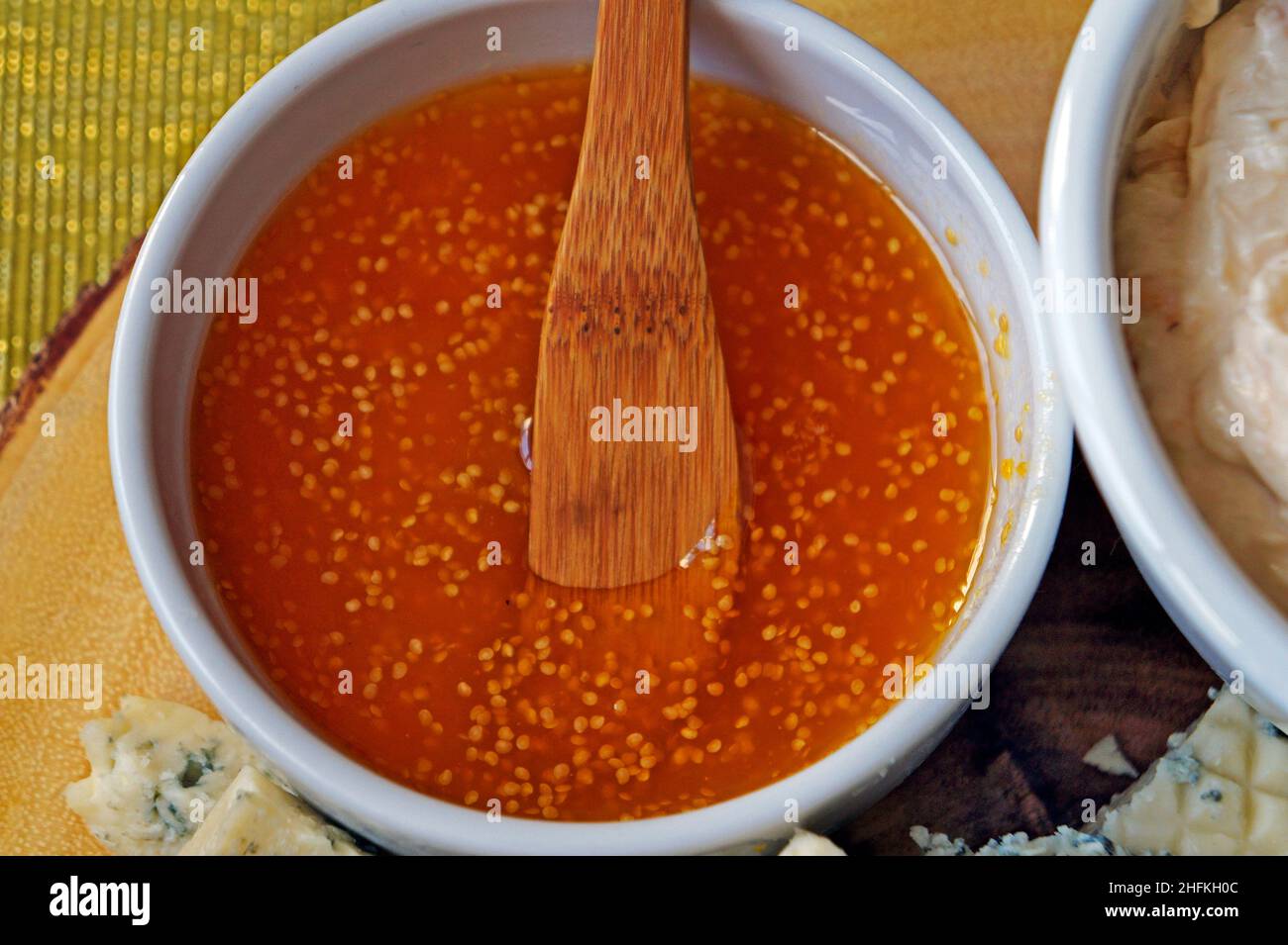 Rote Sauce und Holzlöffel auf dem Tisch Stockfoto