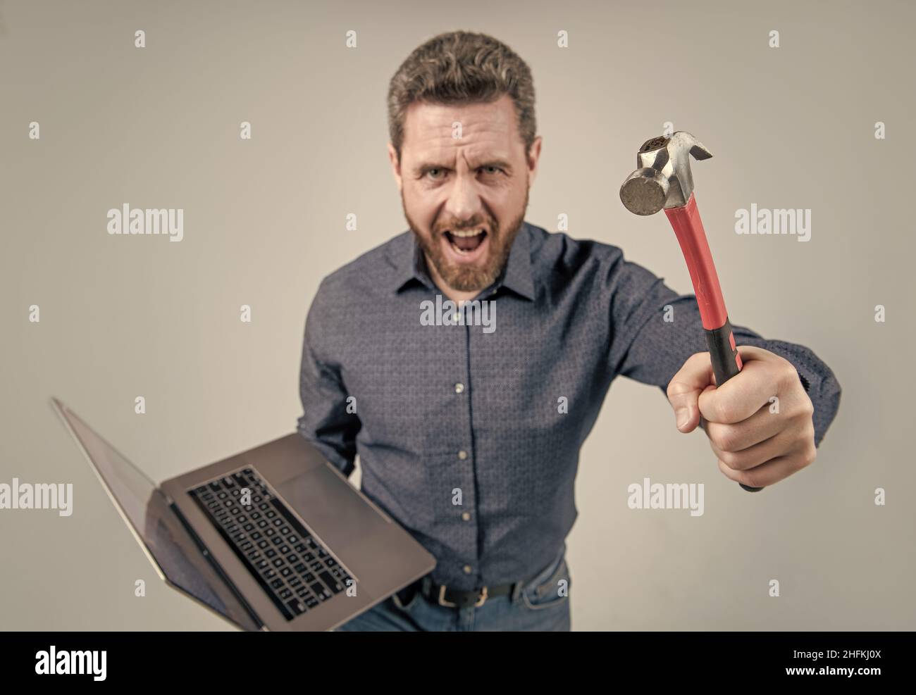 Aufgabe konnte nicht abgeschlossen werden. Wütender Mann, der Hammer und Laptop hält. Computerrage. Wütend Stockfoto