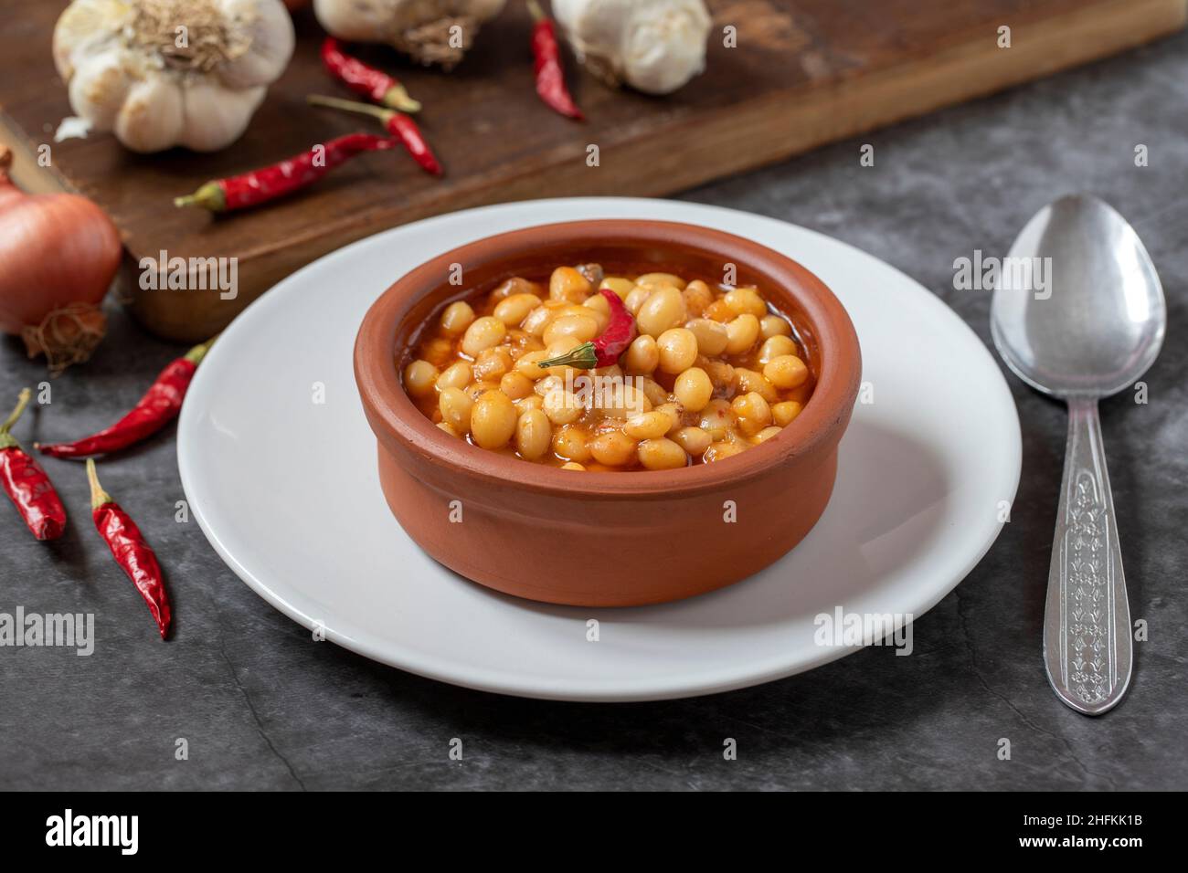 Heißer türkischer Bohneneintopf auf dunklem Hintergrund. Ispir-Bohnen in einer Kasserolle gekocht - Kuru Fasulye Stockfoto