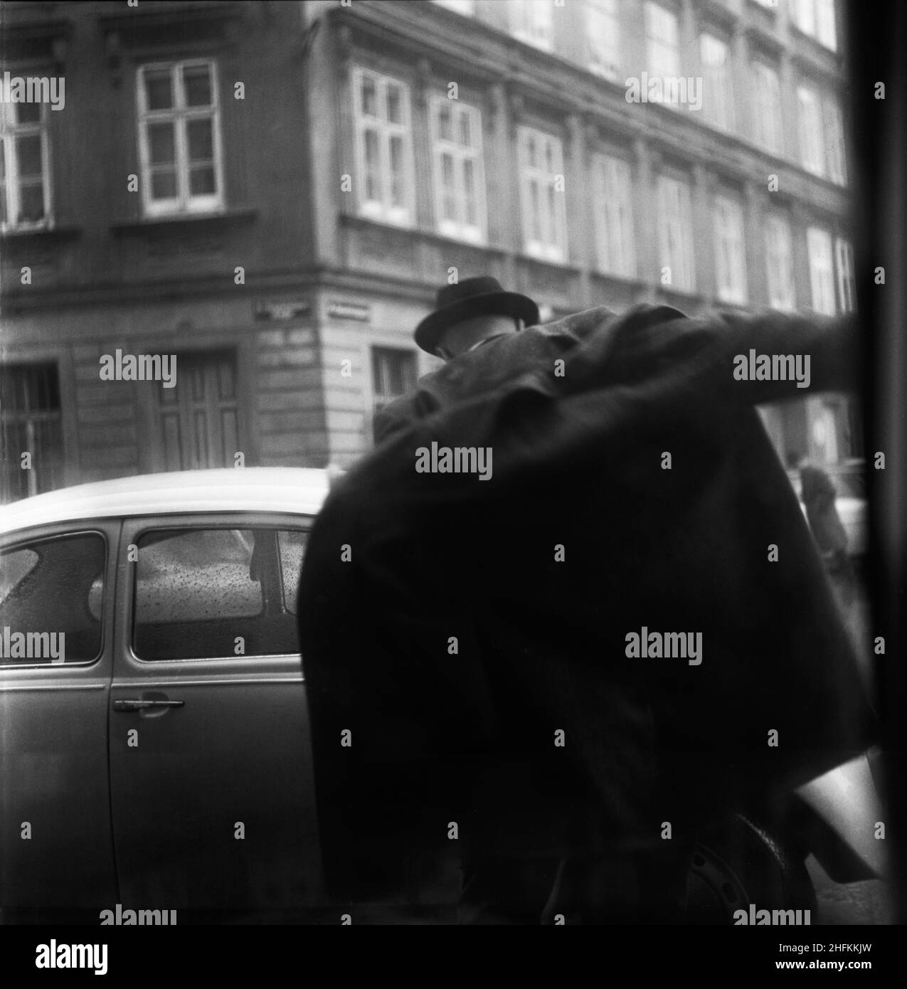 Ein Mann geht nach draußen und zieht sich unterwegs einen Mantel an. Wien, Österreich, Dezember 1971 Stockfoto