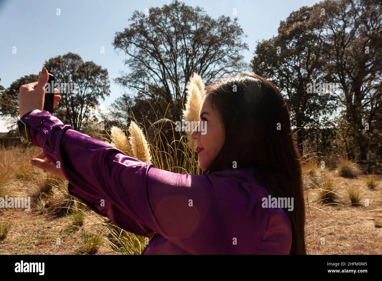 Freiheit Lebensstile kaukasische Frau, die im mexikanischen Bundesstaat ein Selfie mit ihrem Handy gemacht hat, umgeben von Fuchsschwanz und Gras Polypogon monspeliensis outdoo Stockfoto