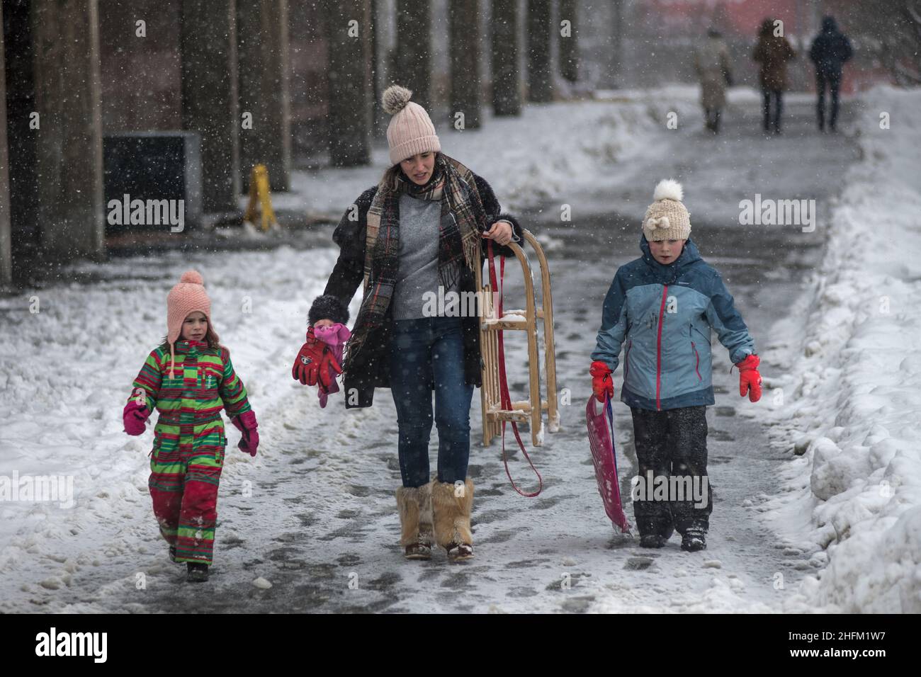 Winter in Serbien: Mutter mit ihrem Sohn und ihrer Tochter im Schnee im Saint Sava Park, Belgrad Stockfoto