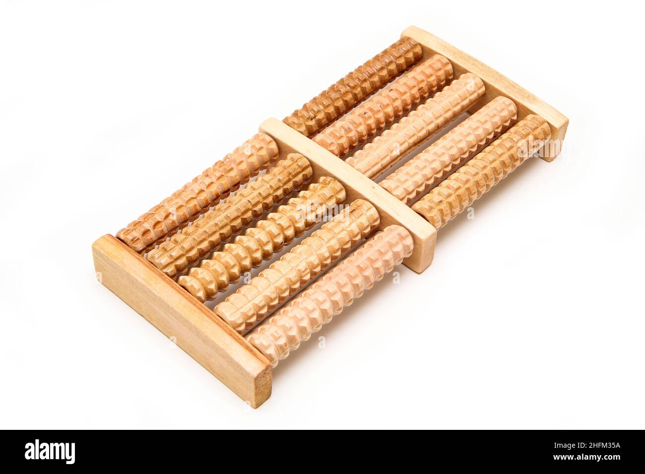 Das kleine Massagewerkzeug aus Holz für die Füße mit kleinen Zahnrollen. Isoliert auf weißem Hintergrund. Stockfoto