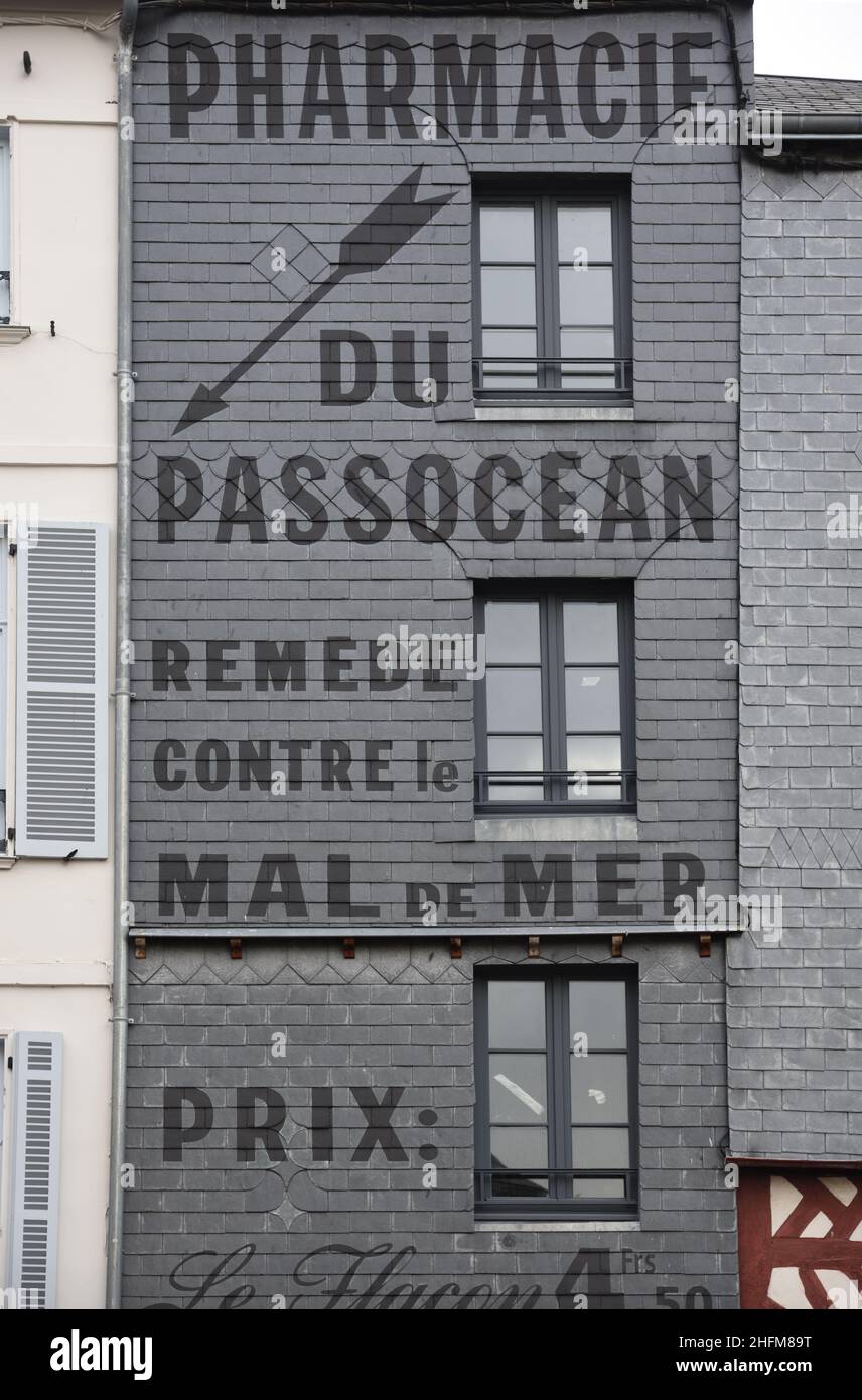 Historisches Gebäude mit Schieferschindeln und Altgemalte Wandwerbung Werbung für ein Heilmittel gegen Seekrankheit oder Seekrankheit Honfleur Normandie Frankreich Stockfoto