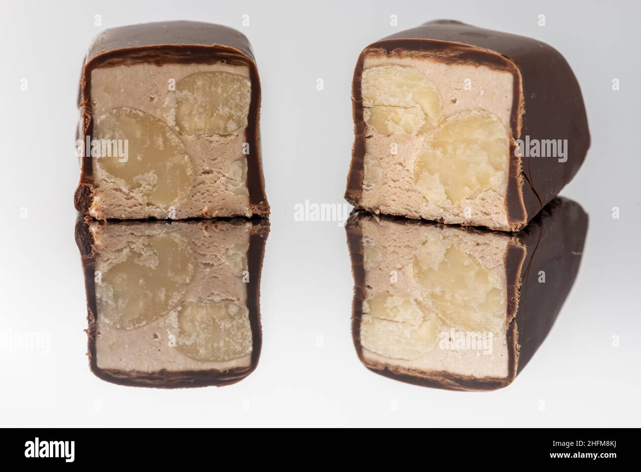 Torrone al cioccolato a pezzi su fondo a specchio Makro Stockfoto