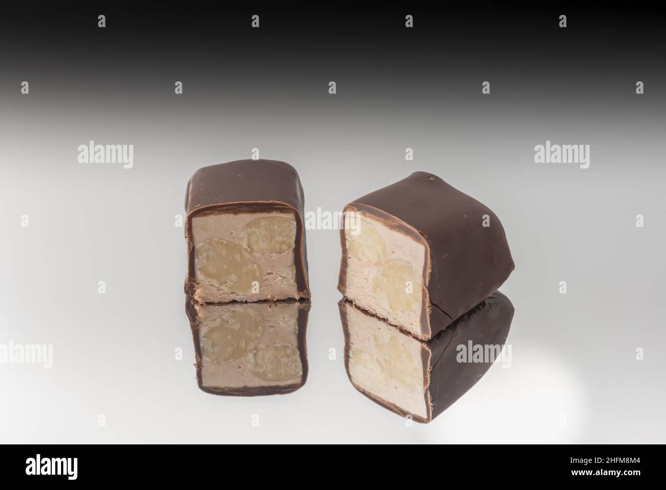 Torrone al cioccolato a pezzi su fondo a specchio Stockfoto