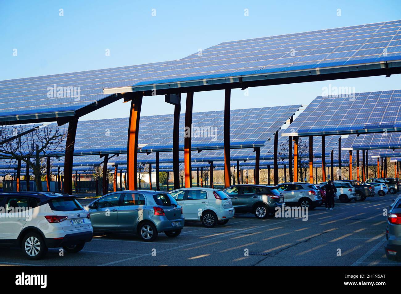 Sonnenkollektoren auf einem Parkplatz. Unternehmen installieren erneuerbare Energiequellen, um ihre CO2-Bilanz zu reduzieren. Padua, Italien - Januar 2022 Stockfoto