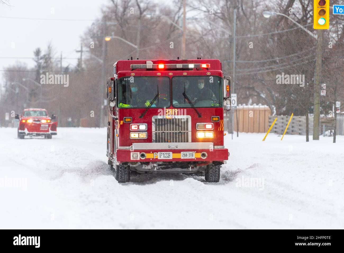 Ein Feuerwehrauto oder Feuerwehrauto rast irgendwo in der Victoria Park Avenue während eines Winterschneesturms in Toronto, Kanada, mit seiner Sirene dröhnend Stockfoto