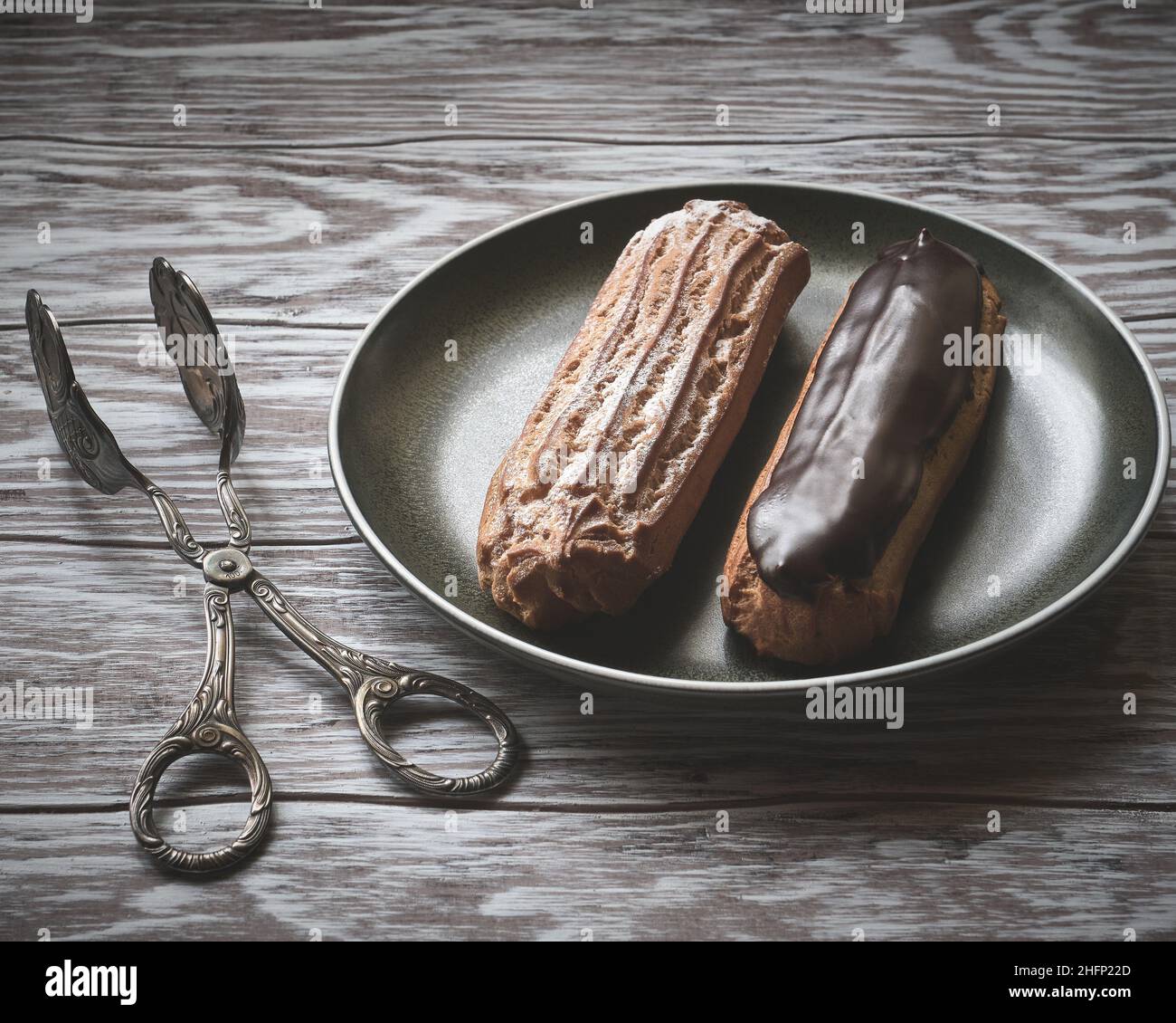 Köstliche süße Ecolirs und Kuchenzangen aus der Nähe, stilisiert im Retro-Stil Stockfoto