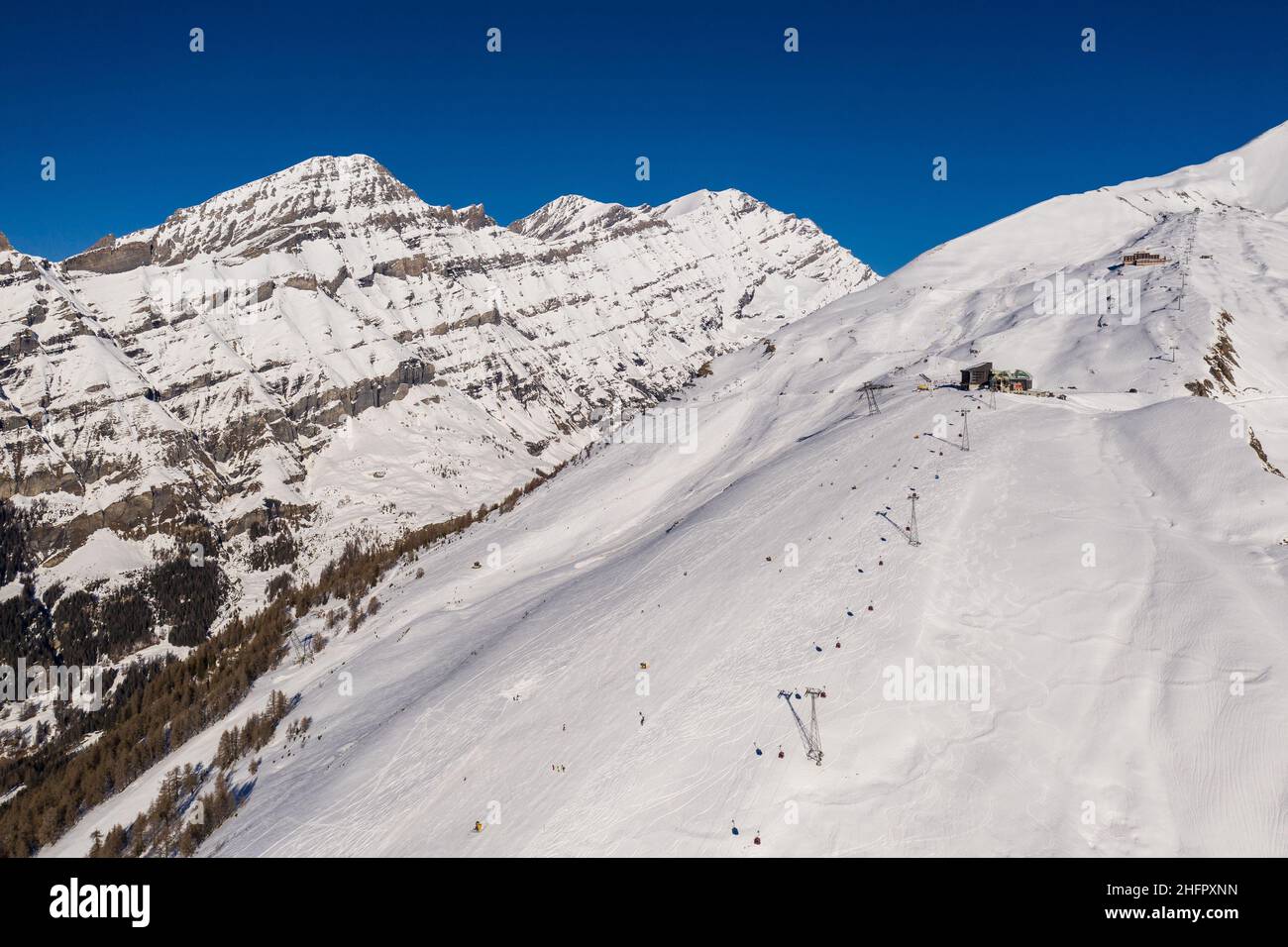 Luftaufnahme des Skigebiets Leukerbad und der Seilbahnstation in den alpen im Kanton Wallis in der Schweiz an einem sonnigen Wintertag. Stockfoto