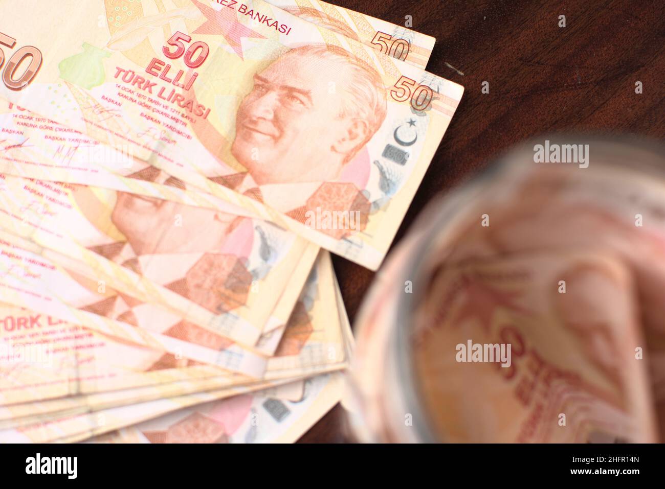 Etwa 50 türkische Liras in einem Glas auf braunem Hintergrund zu retten. Stockfoto