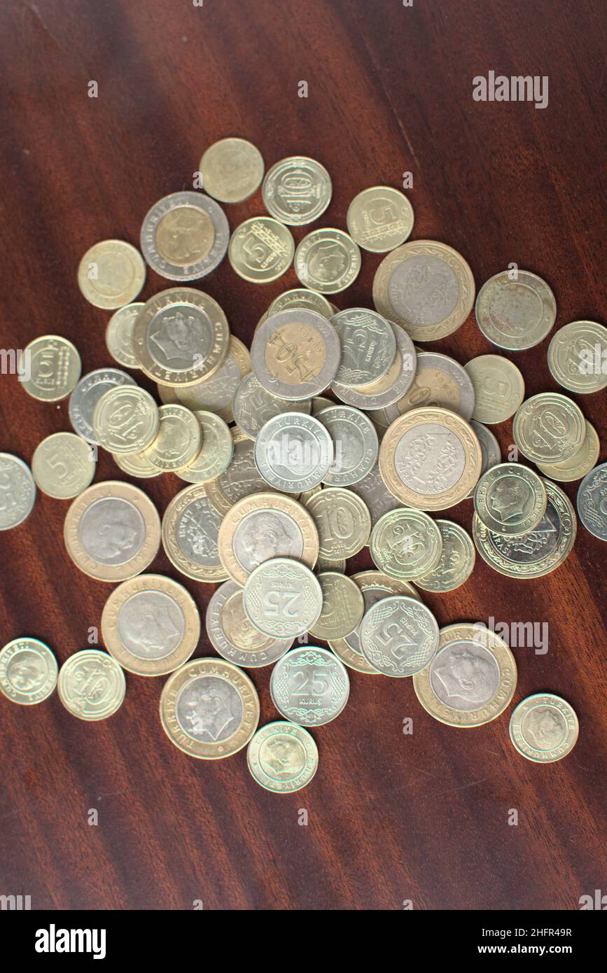 Einige türkische Münzen auf braunem Hintergrund gemischt. Einige türkische Liras auf einem braunen Tisch. Voll von Geldbeutel. Stockfoto
