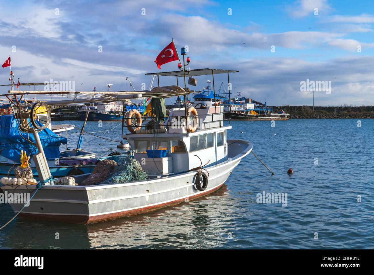 Ein kleines Fischerboot unter türkischer Flagge ist in einem kleinen Fischerhafen vertäut. Arakli, Trabzon, Türkei Stockfoto