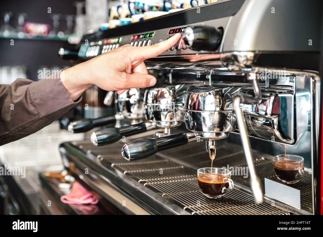 Klassischer Barista, der italienischen Espresso auf die Kaffeebar-Maschine in der Fashion Cafeteria gießt - Konzept der Lebensmittel- und Getränkeindustrie mit einem professionellen Barkeeper Stockfoto