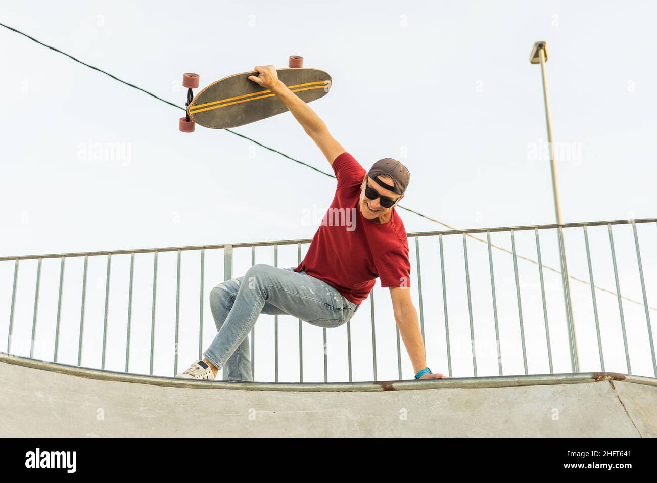 Glücklicher erwachsener Mann, der mit einer Skate-Brandung auf einer Rampe zieht Stockfoto