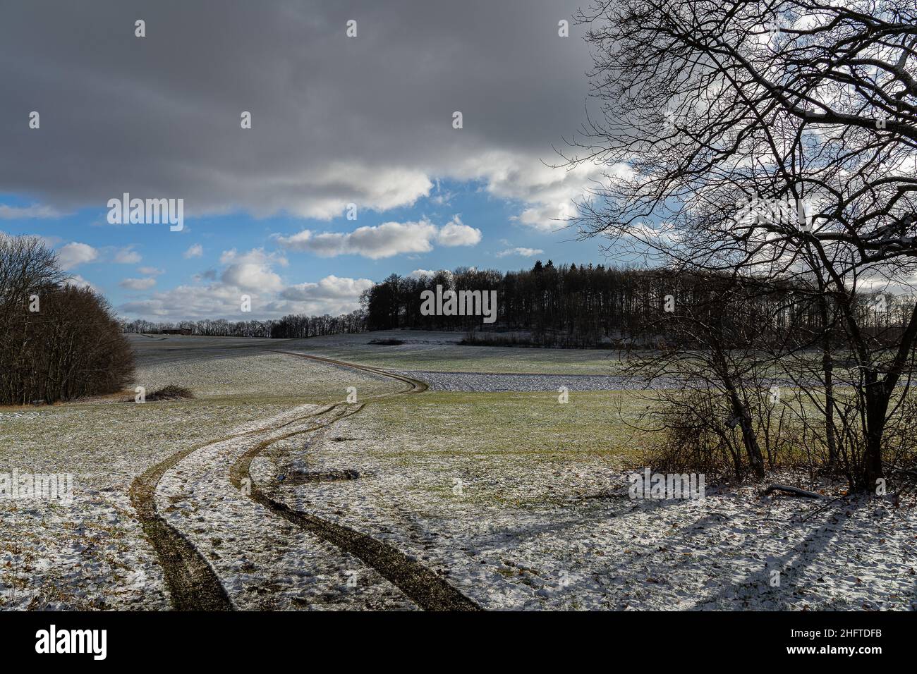 Blick auf ein leicht schneebedecktes Feld im Winter mit pastellfarbenen Farben Stockfoto