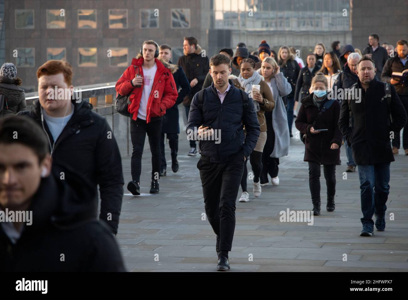 London Pendler an einem frischen Wintermorgen machen sich auf den Weg in die City of London, während die Sonne aufgeht und Arbeiter in ihr Büro zurückkehren, Januar 2022 Stockfoto