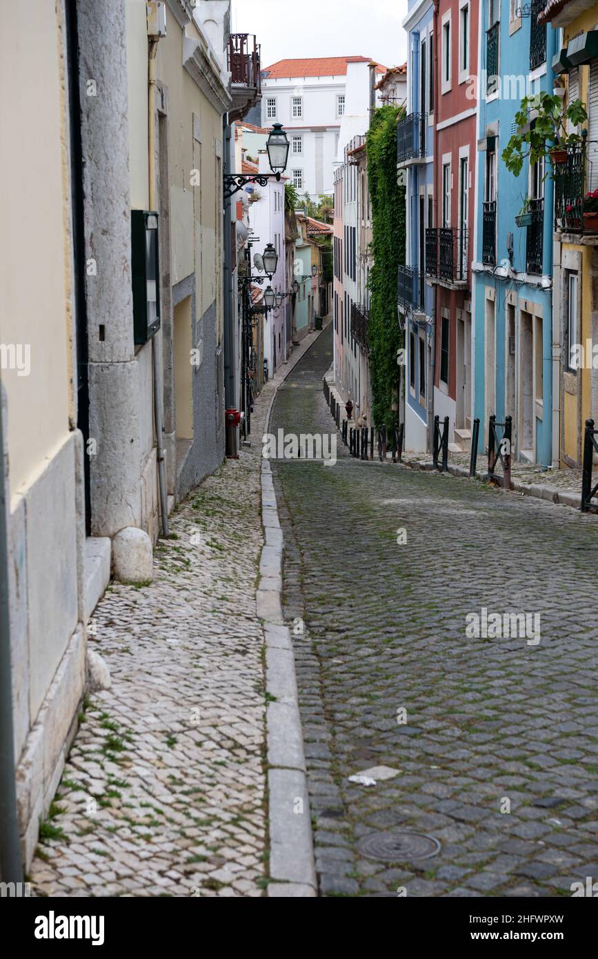 Traditionelle urbane Wohnhäuser in einer hügeligen Kopfsteinpflasterstraße in Lissabon Portugal Stockfoto