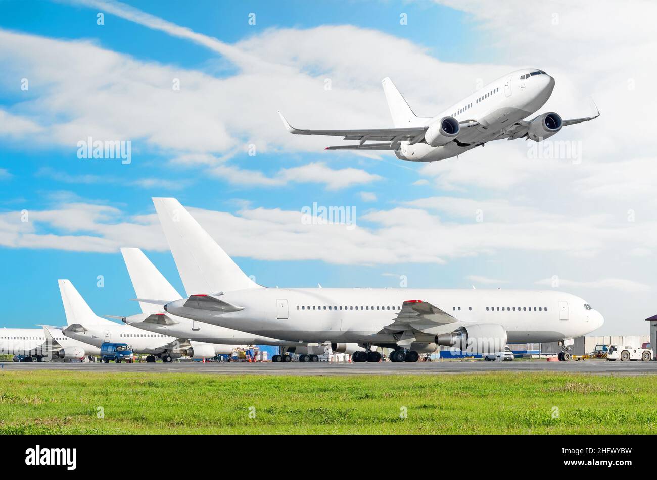 Passagierflugzeug, das vor dem Abflug am Flughafen geparkt wurde, anderes Flugzeug schiebt zurück. Das Flugzeug fliegt auf die Landebahn am Himmel Stockfoto