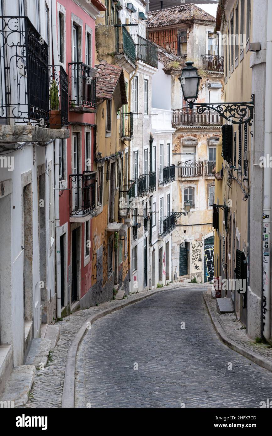 Reihe von traditionellen städtischen Wohnhäusern in hügeliger Nachbarschaft Kopfsteinpflasterstraße im Stadtteil Bica in Lissabon Portugal Stockfoto