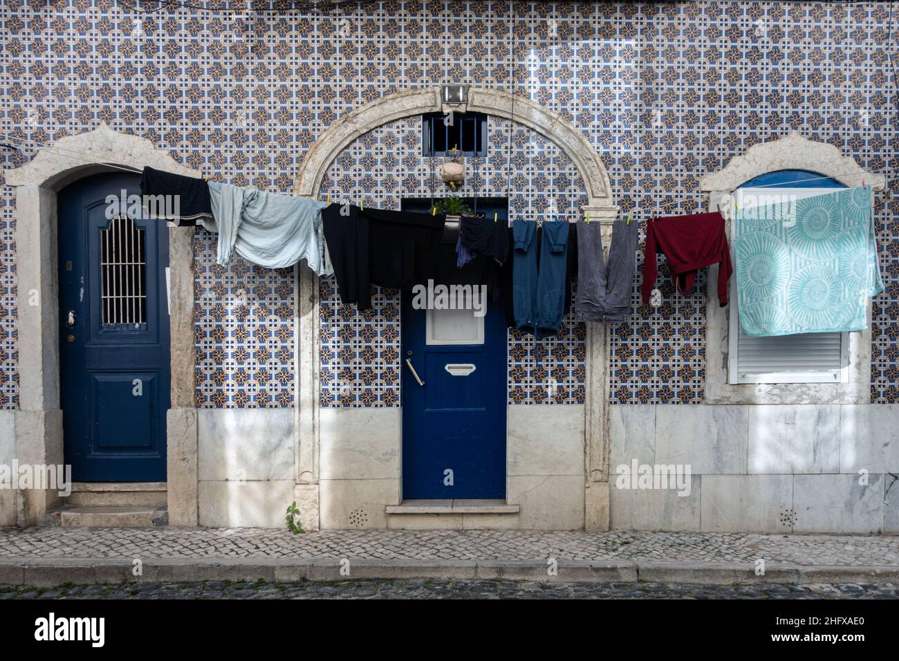 Architektonische Details Nahaufnahme der traditionellen keramischen Wandfassade des Wohngebäudes mit unauffindbaren Eingängen zur Straße mit anliegenden Kleidern Stockfoto