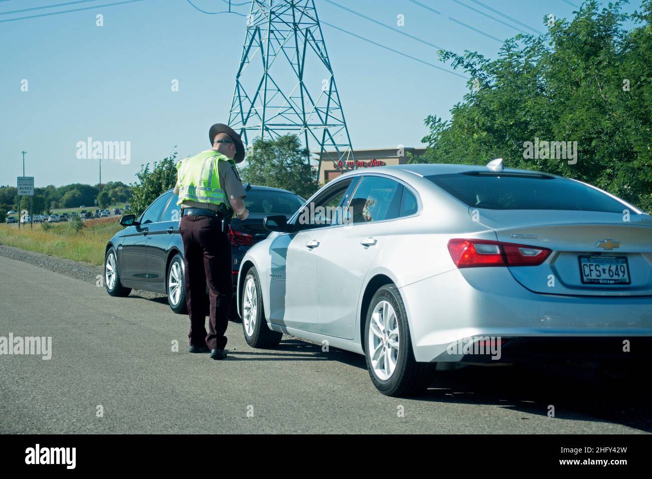 Polizeibeamter auf der Autobahn, der einem Fahrer ein Ticket gibt. Minneapolis Minnesota, USA Stockfoto