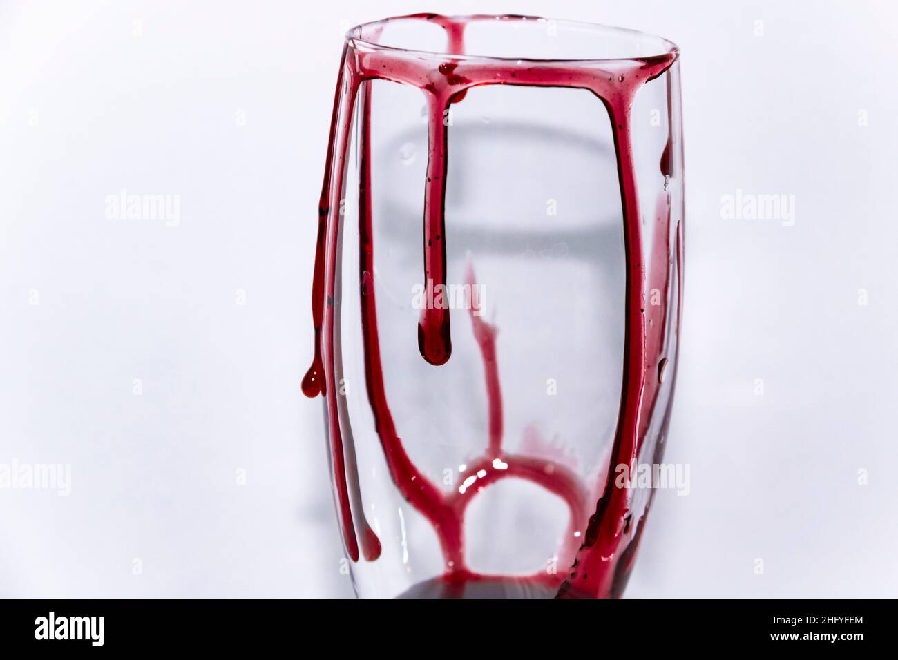 Ein Blick auf die Hälfte des Glases, auf der Blut fließt. Blutiges Weinglas – konzeptuelles Foto. Stockfoto