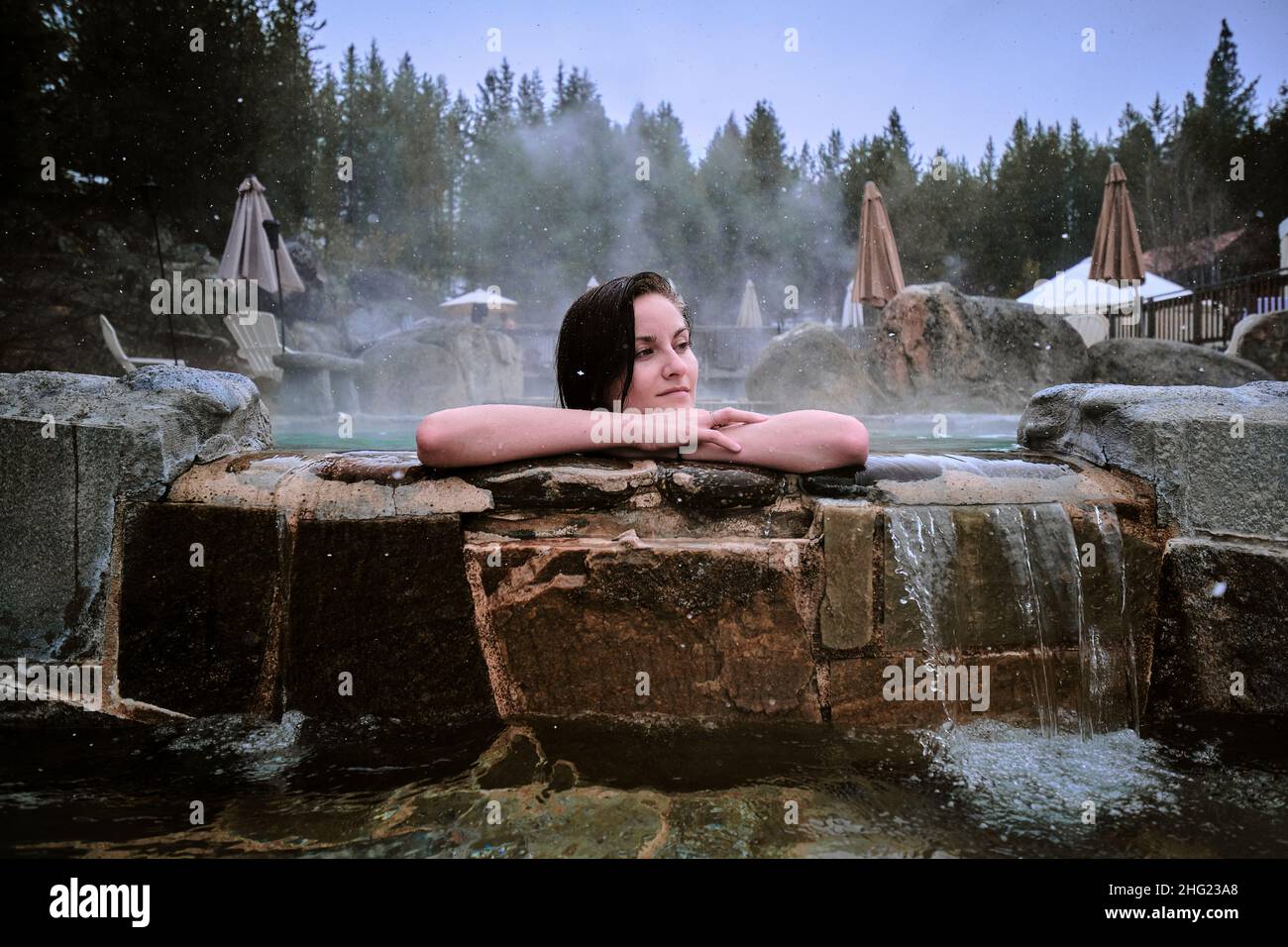 Junge Frau genießt entwickelte heiße Quellen in einem Winter in Idaho. Stockfoto