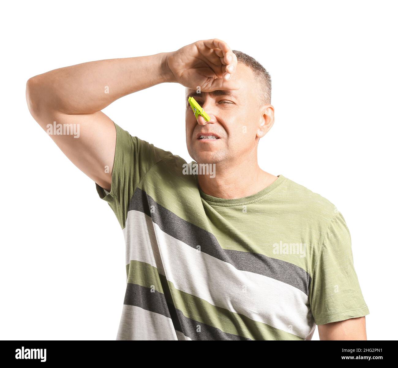 Kranker reifer Mann mit Wäscheklammer auf der Nase vor weißem Hintergrund Stockfoto