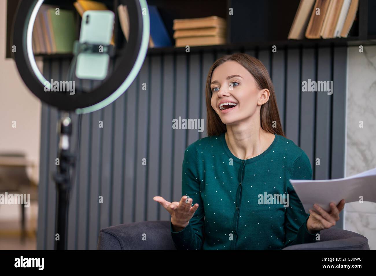 Aufgeregte junge Frau führt ein Online-Tutorial Stockfoto