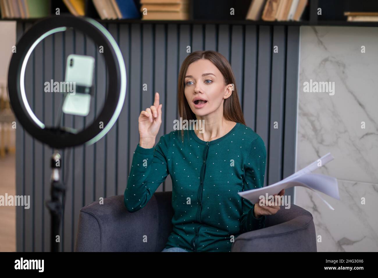 Aufgeregte junge Frau führt ein Online-Tutorial Stockfoto