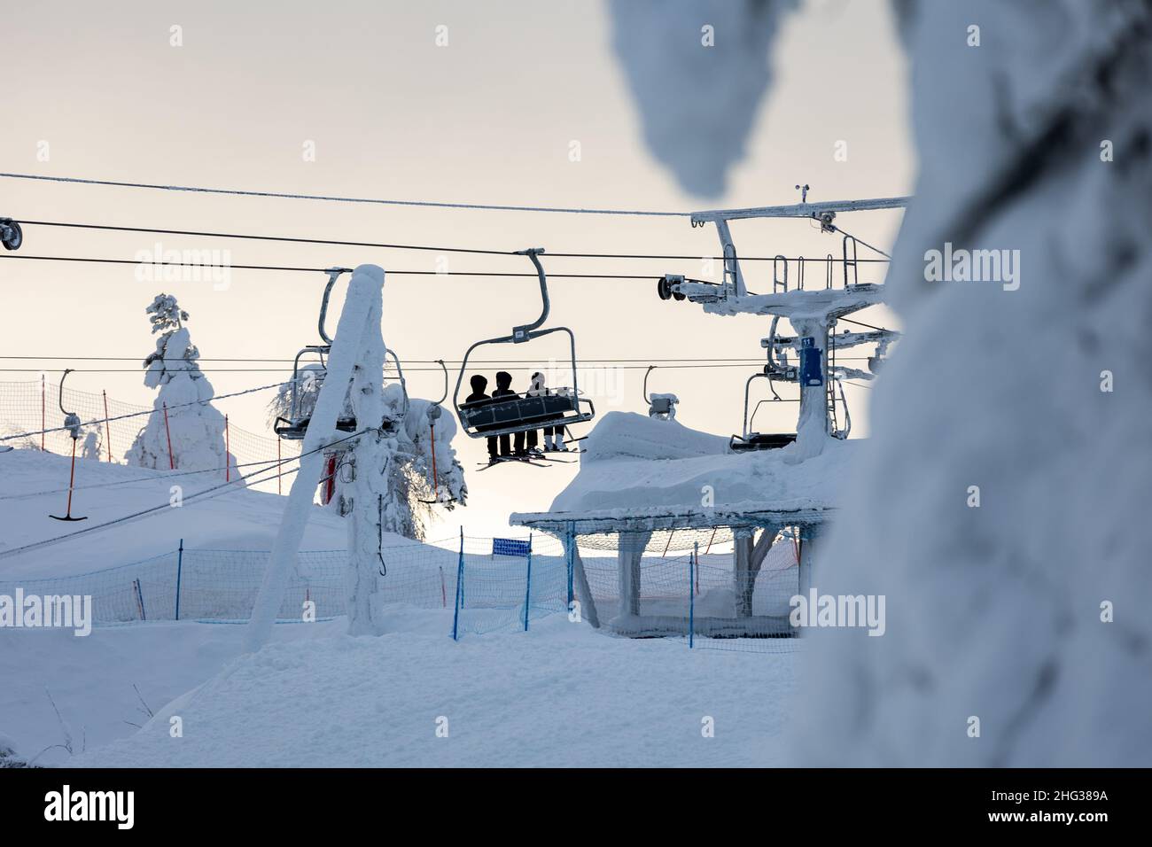 Menschen auf einem Sessellift in der Schneelandschaft in Finnland. Stockfoto