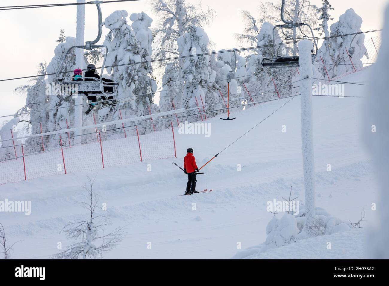 Vuokatti, Finnland - January2022: Menschen im Skilift gehen zum Skifahren in Vuokatti Pisten Skigebiet. Stockfoto